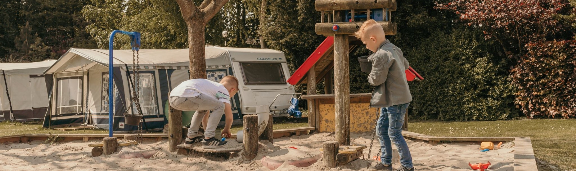 Kinderen spelen bij de zand- en waterspeelplaats op camping Kotestee in Ouddorp.