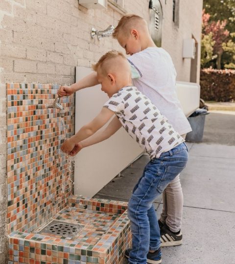 Kinderen wassen hun handen bij het sanitair op camping Kotestee in Ouddorp.