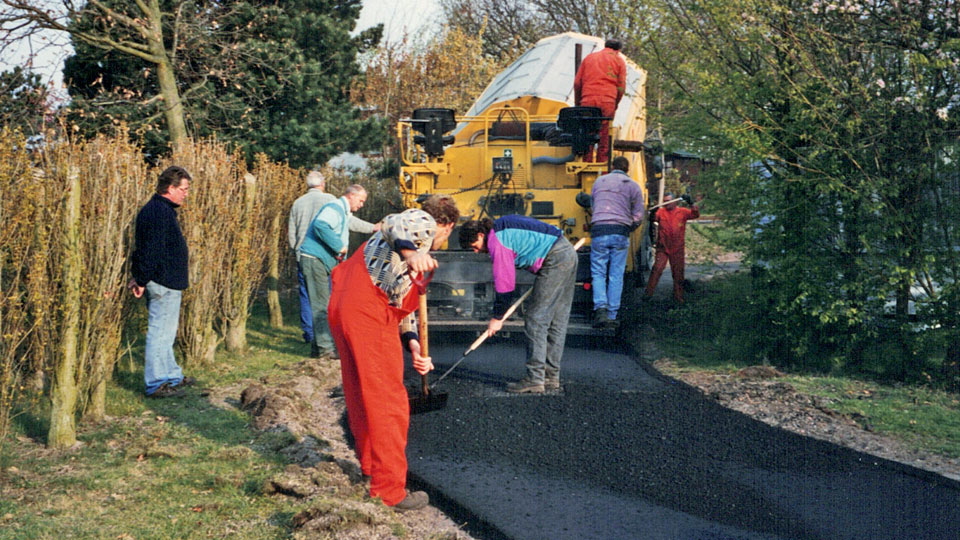 Piet Polie kijkt toe hoe de paden op camping Kotestee geasfalteerd worden in de jaren negentig.
