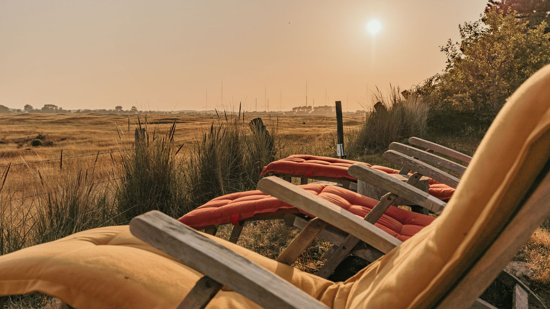 Ligstoelen met zonsondergang bij de Westduinen naast camping Kotestee